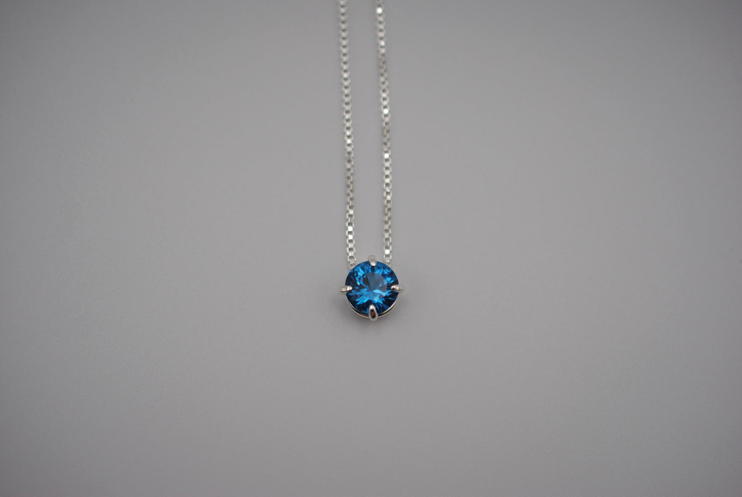 Birthstone Necklace: Round Blue Zircon, Silver Prong Setting, Adjustable Chain