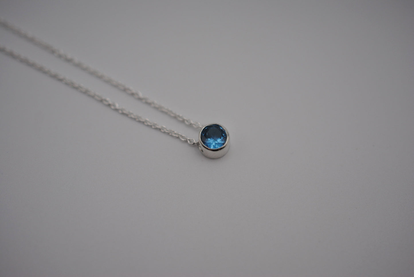 Birthstone Necklace: Round Blue Zircon, Bezel, Silver, Cable Chain