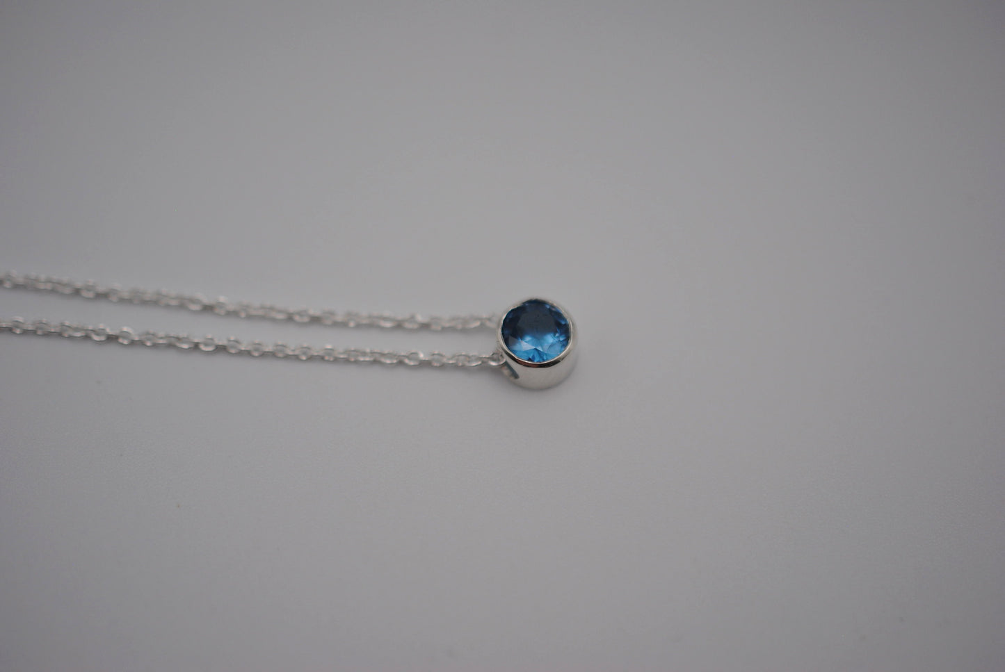 Birthstone Necklace: Round Blue Zircon, Bezel, Silver, Cable Chain