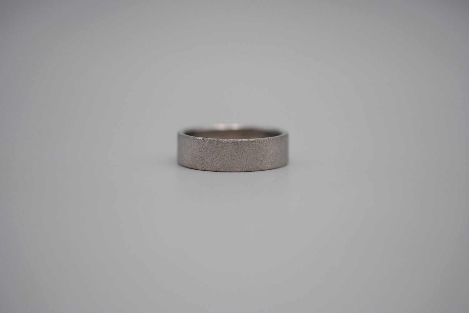 A ring band with a unique matte texture. Finished in rhodium, a platinum. It's 6mm in width.