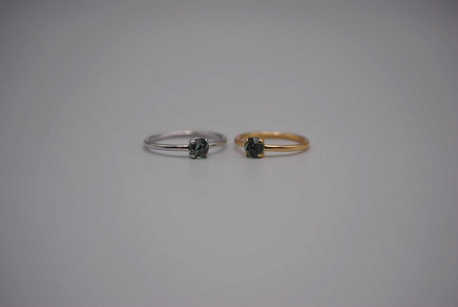 A wedding set of two similar minimalist rings. Both are rose cut Sapphies. One is White Gold and the other Yellow Gold. 