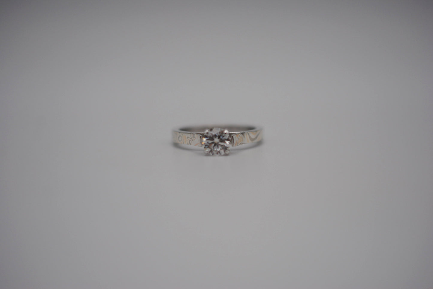 Moissanite Ring: Round Cut, Mokume Game Cathedral Band, White Gold Setting