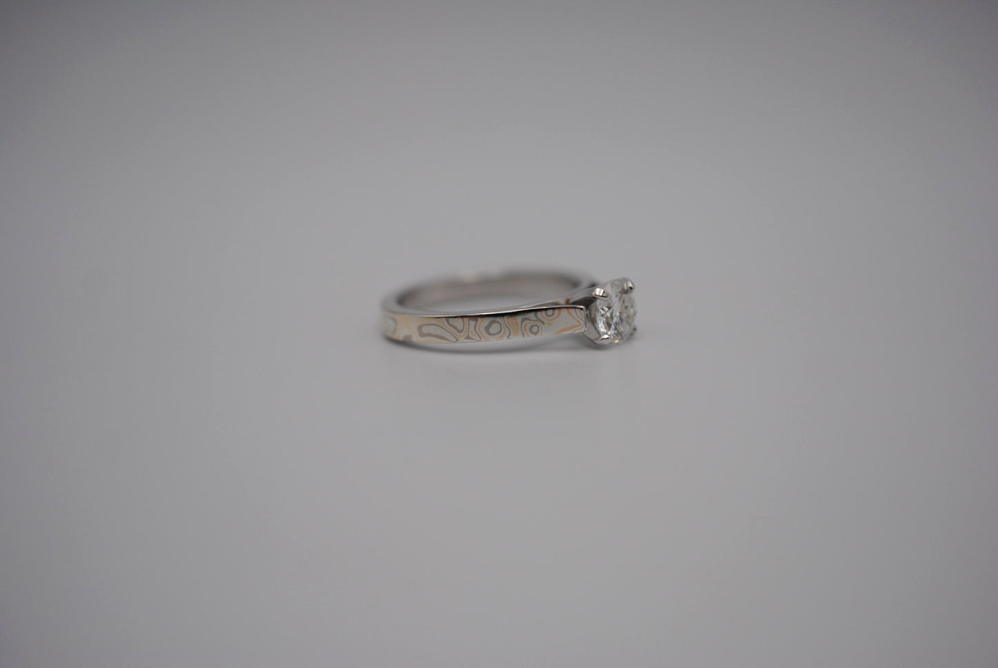 Moissanite Ring: Round Cut, Mokume Game Cathedral Band, White Gold Setting